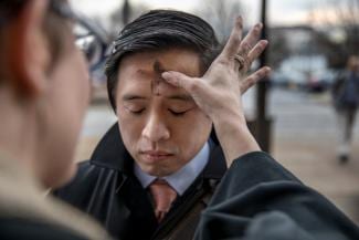 The Rev. Robin Anderson puts glitter ashes on a man’s forehead outside the Braddock Road Metro station in Alexandria. (Evelyn Hockstein for The Washington Post) styles medium public images blog posts Adam Dupuis 2017 03 01 imrs 1