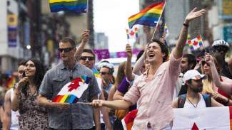 Prime Minister Justin Trudeau gets splashed with water as he waves a flag while taking part in the annual Pride Parade in Toronto on Sunday, July 3, 2016. (Nathan Denette/The Canadian Press) styles medium public images blog posts Adam Dupuis 2017 05 01 web trudeau 0
