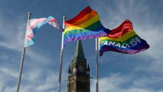 The pride and transgender flags fly on Parliament Hill following a ceremony with Prime Minister Justin Trudeau in Ottawa, Wednesday June 14, 2017. (Adrian Wyld / THE CANADIAN PRESS) styles medium public images blog posts Adam Dupuis 2017 06 16 image