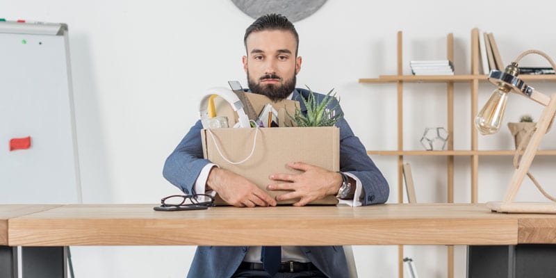 A fired employee sits at his desk